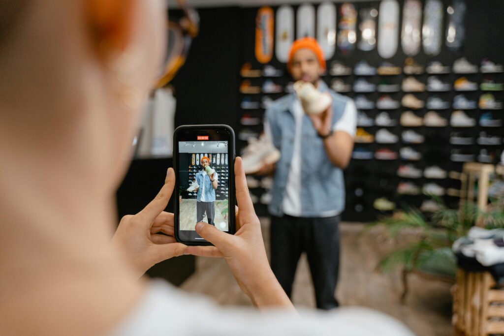 Person filming a shoe shopping experience in a trendy store using a smartphone.